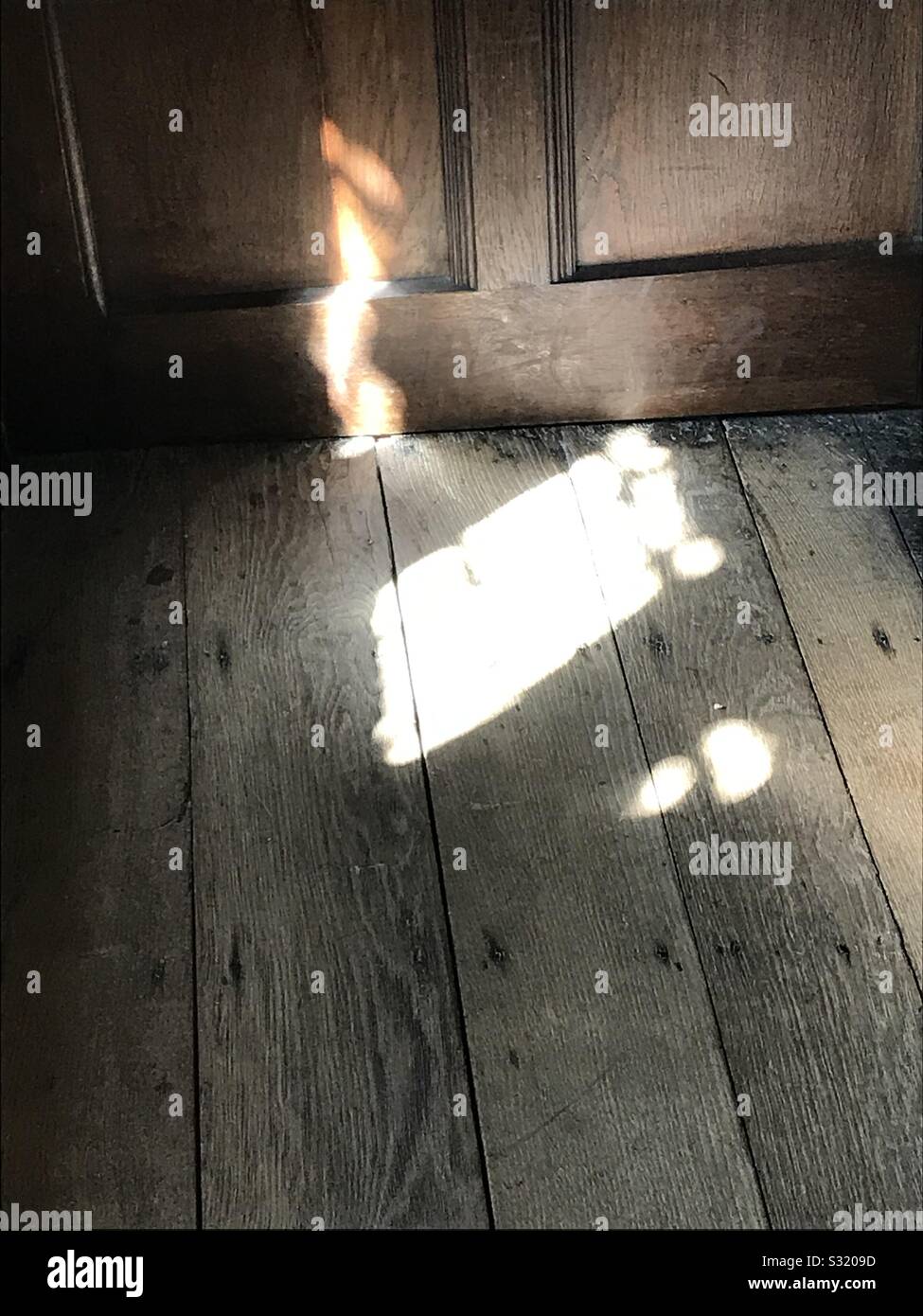Warm sun light casted on old wooden door and floor interior - Smartphone Captured Stock Image