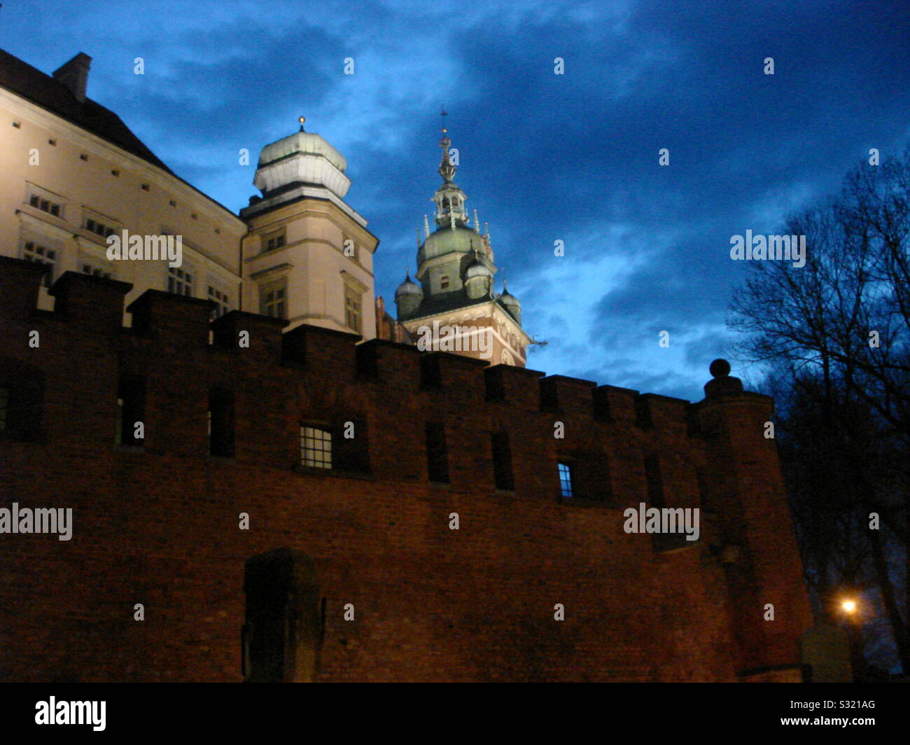 Close up of Wawel Castle wall and towers at dusk. Silhouetted against blue sky cloudscape. - Smartphone Captured Stock Image