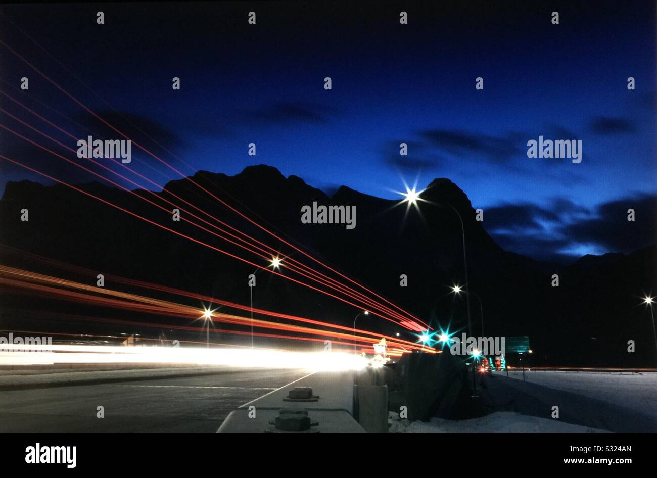 Early morning, taillights, head lights ,Transcanada highway, Canadian Rockies,  Banff National Park, Alberta, Canada Stock Photo