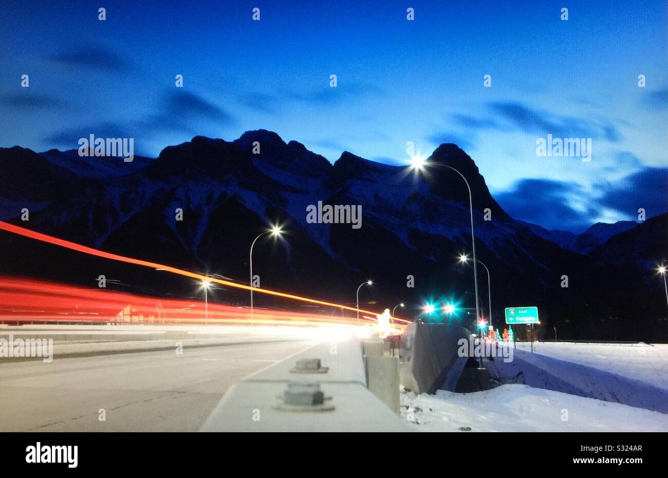 Early morning, taillights, head lights ,Transcanada highway, Canadian Rockies,  Banff National Park, Alberta, Canada Stock Photo