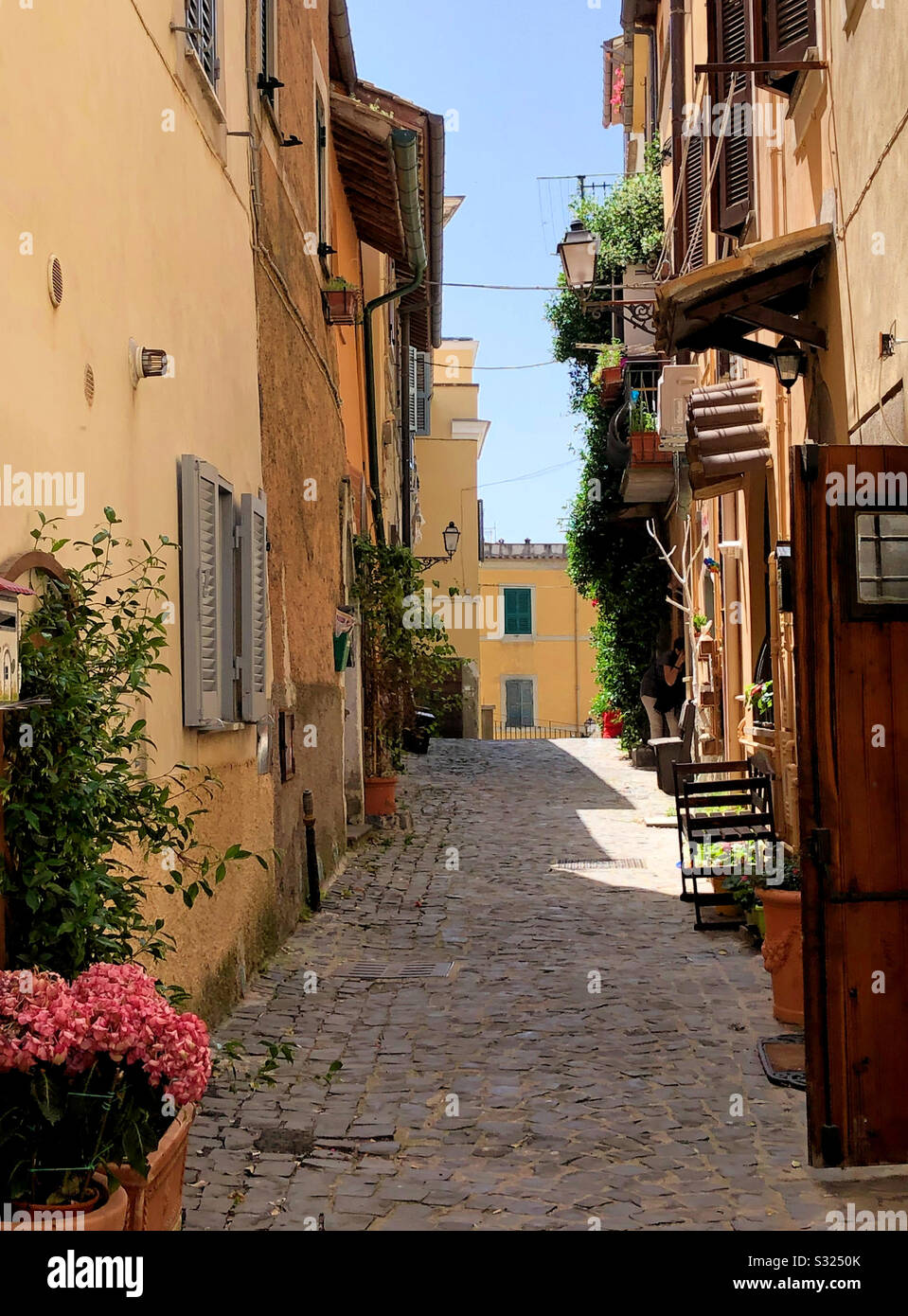 Empty Italian cobbled street in summertime Stock Photo