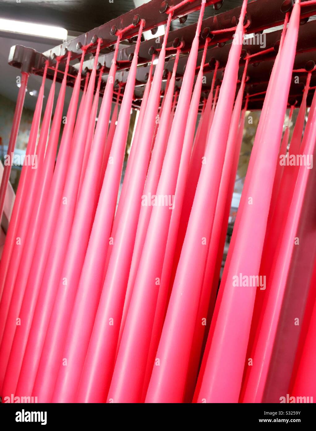 A hanging display of tape or pink candles for sale in a shop in the United States - Smartphone Captured Stock Image
