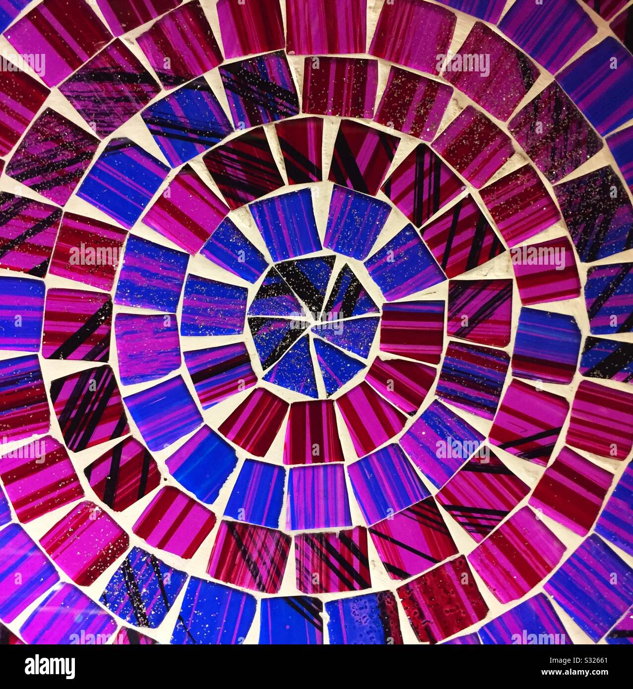 Vibrant and colourful mosaic tiles in a circular pattern with purples and blues in a colourful ceramic background image Stock Photo
