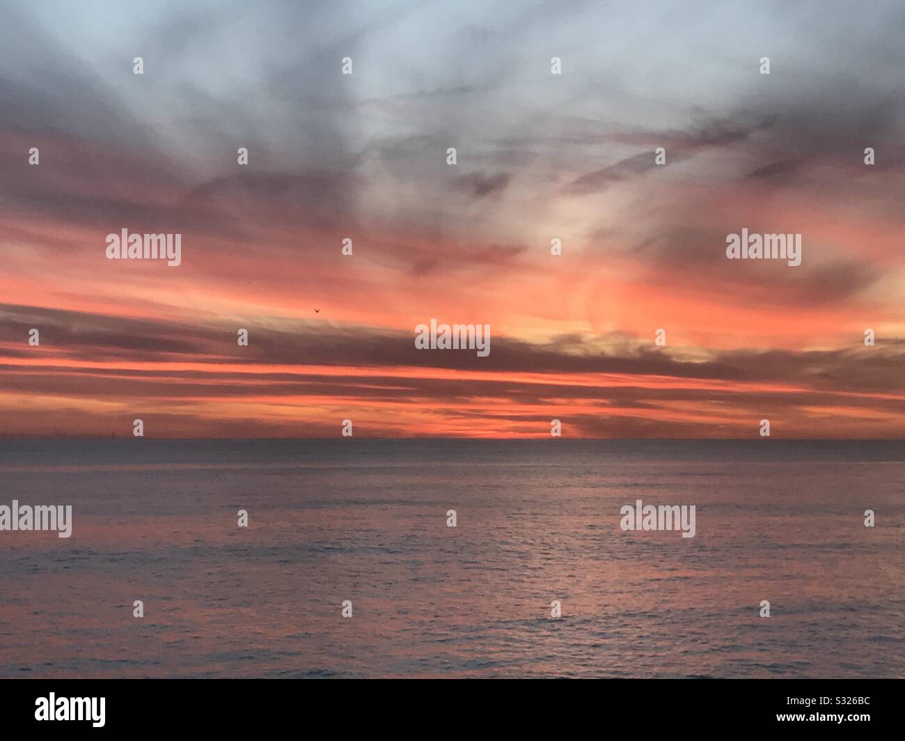 Red sunset over Brighton with crepuscular rays. - Smartphone Captured Stock Image