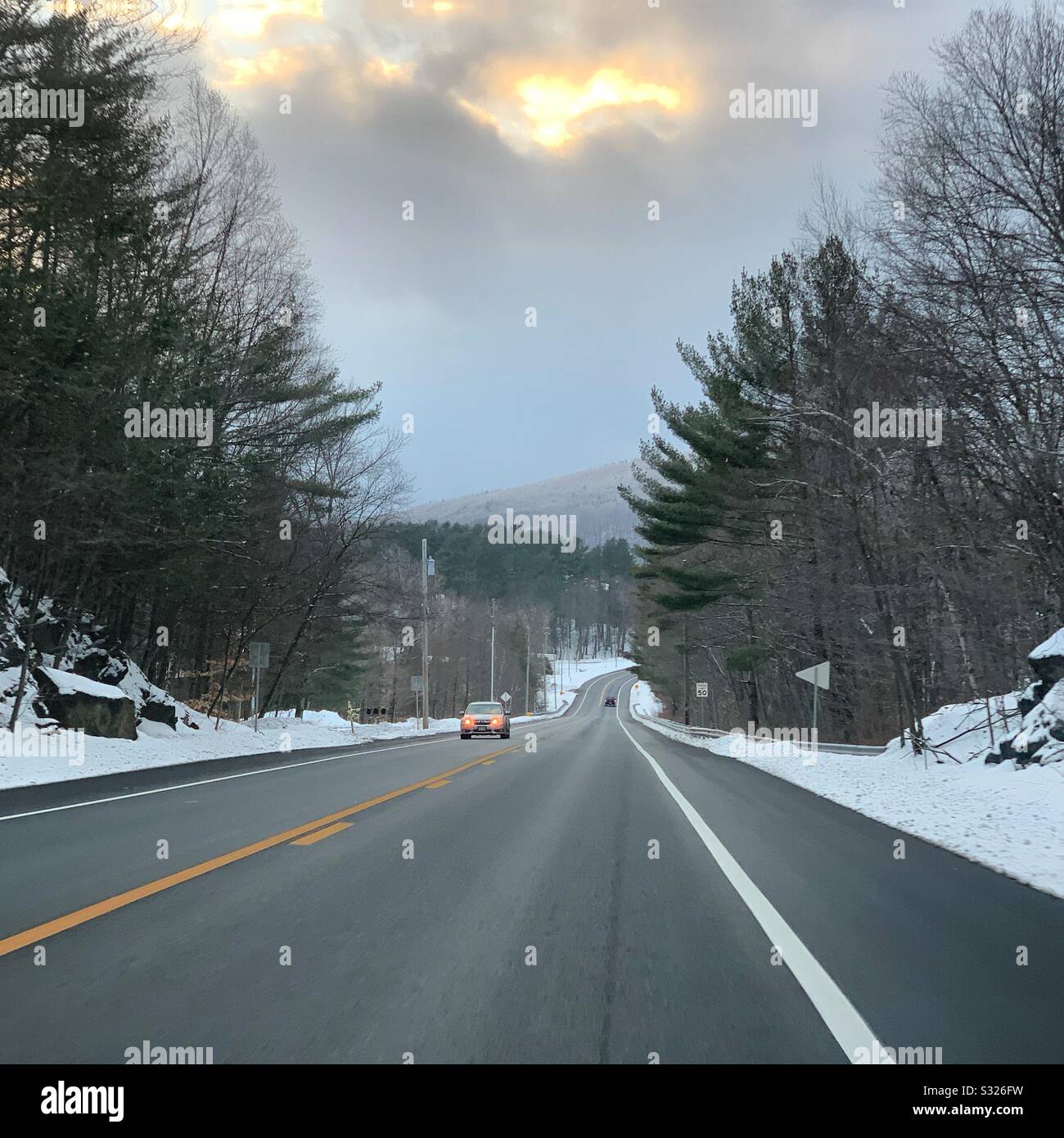 Sun peaks through clouds during a winter drive in Massachusetts, United States - Smartphone Captured Stock Image