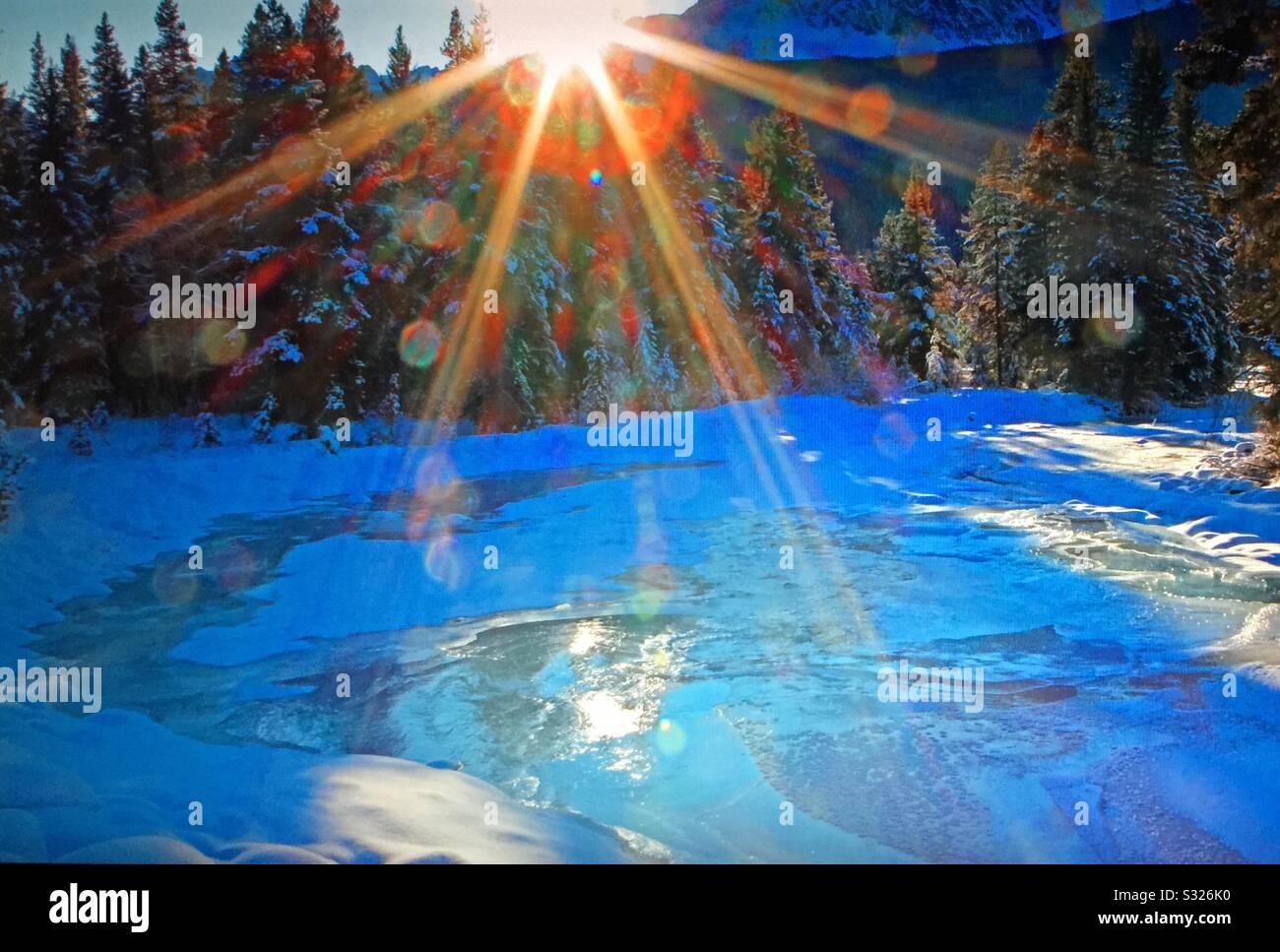 Travel Alberta, Baker Creek, lens flares, winter sun, Banff National Park, Alberta, Canada. - Smartphone Captured Stock Image