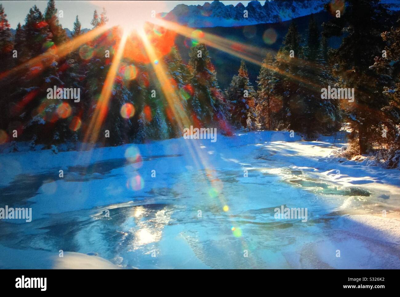Travel Alberta, Baker Creek, lens flares, winter sun, Banff National Park, Alberta, Canada. - Smartphone Captured Stock Image