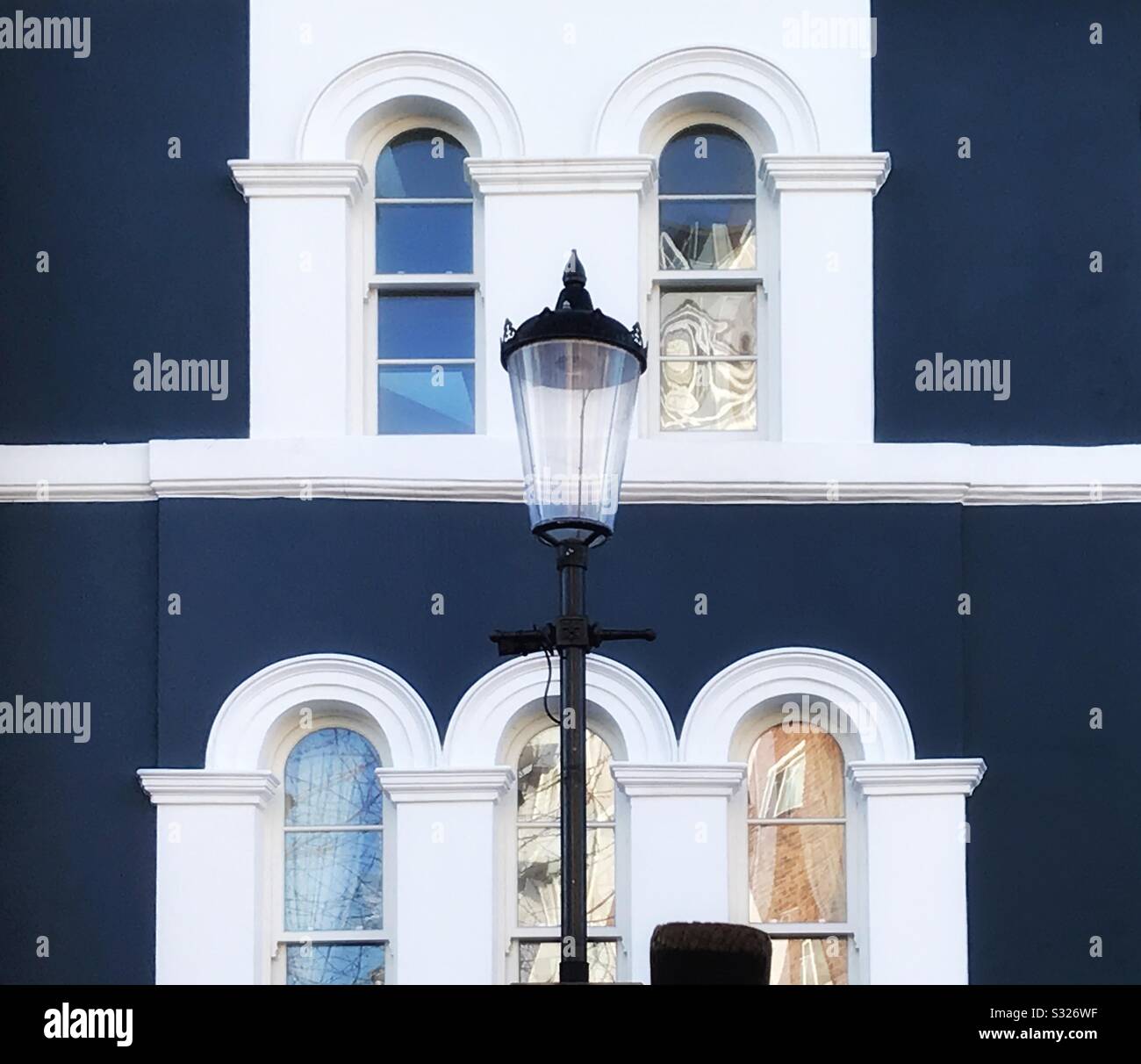 A street lamp in front of a house in London’s Portobello Road Notting Hill is in keeping with the architectural style as illustrated by the windows and and painted facade in the background Stock Photo