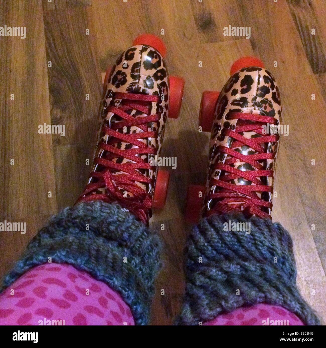 A woman’s feet in roller skates seen from above with colourful leg warmers and leggings Stock