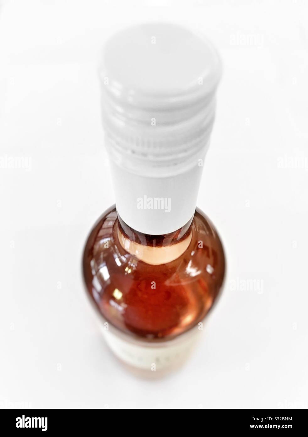 Looking down on a bottle of rose wine on white background. - Smartphone Captured Stock Image