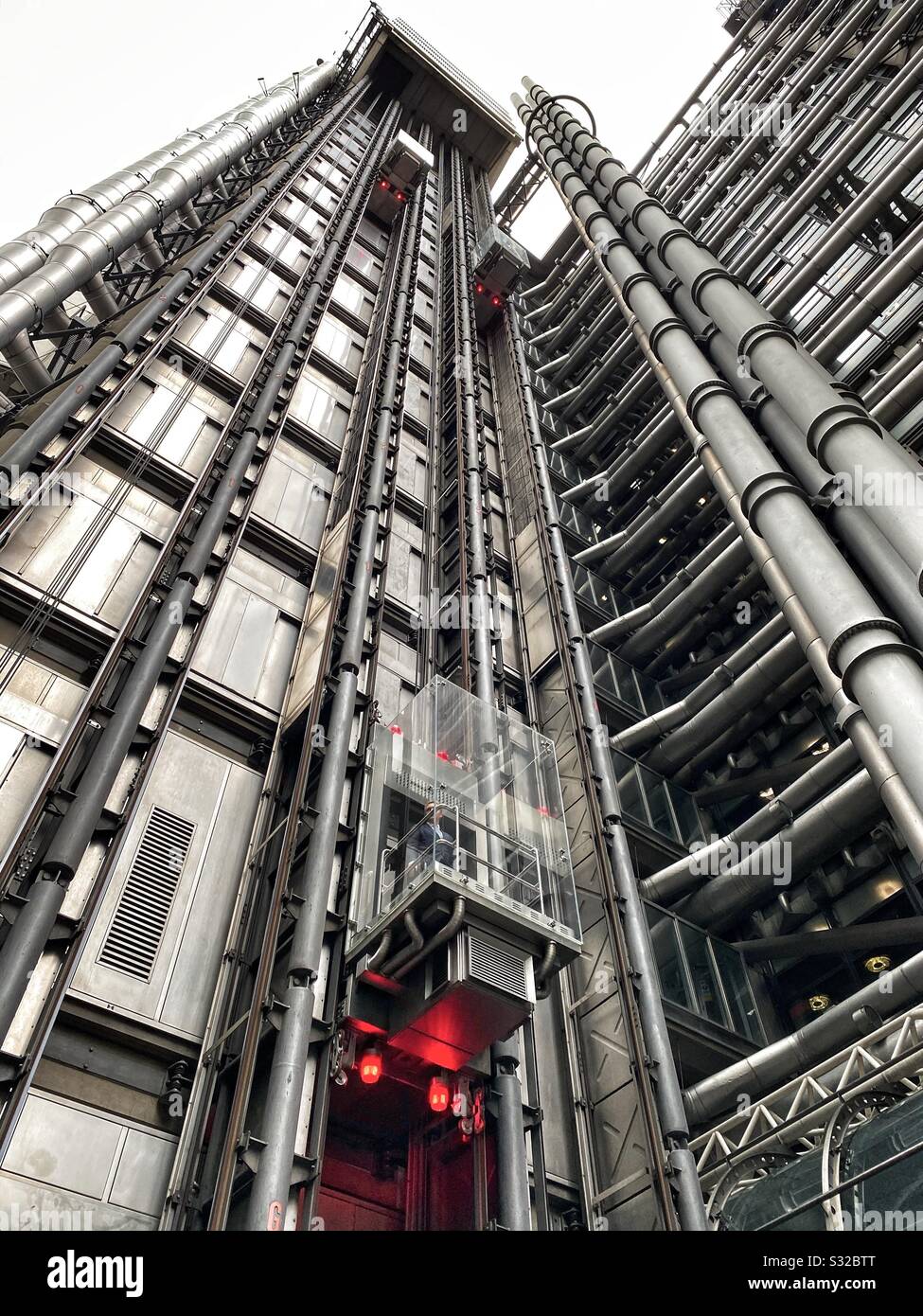 Passengers travel in the lifts in the Lloyd’s of London building in London, England - Smartphone Captured Stock Image