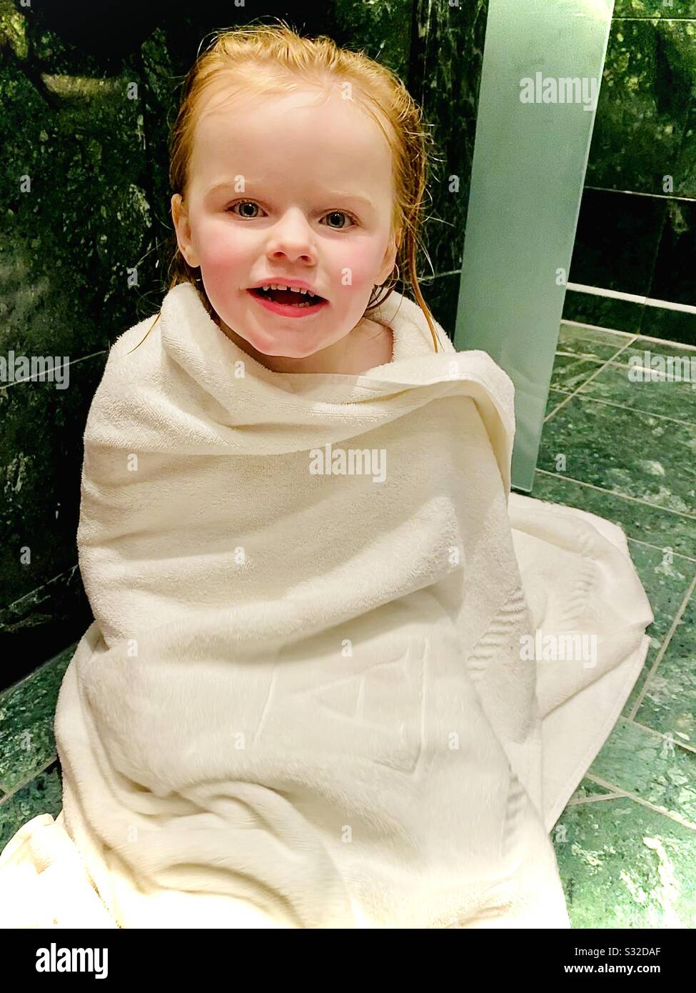 3 year old girl wrapped in a towel out of the bath Stock Photo Alamy