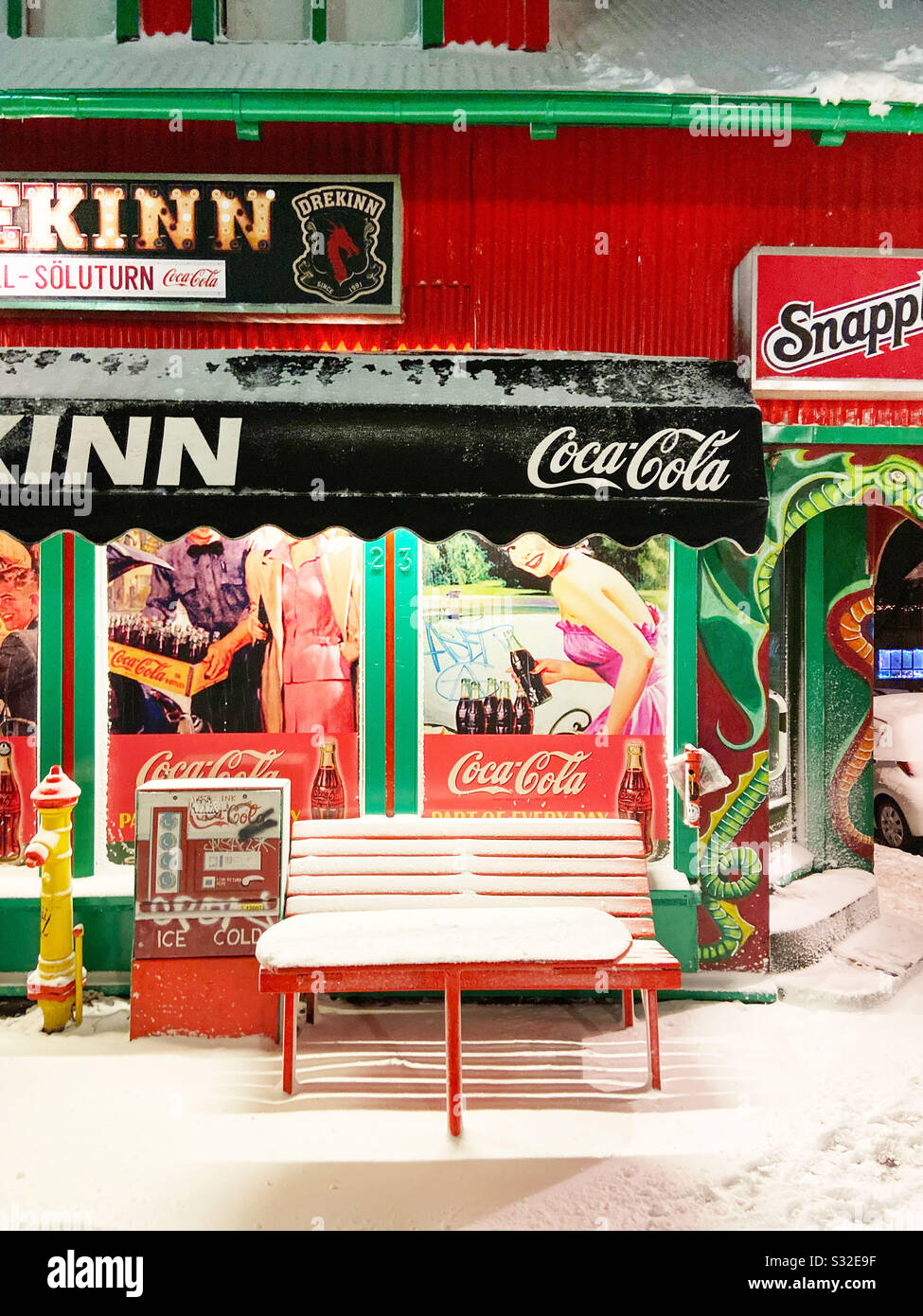 A red bench covered in snow outside a corner store in Reykjavik, Iceland on December 11, 2019. Stock Photo