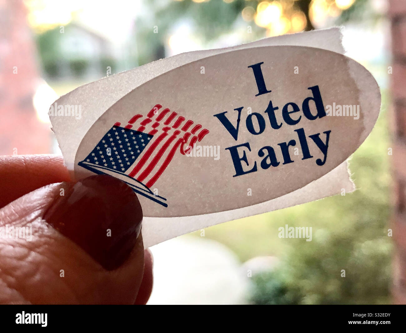 I voted early sticker on a middle aged woman’s finger - Smartphone Captured Stock Image