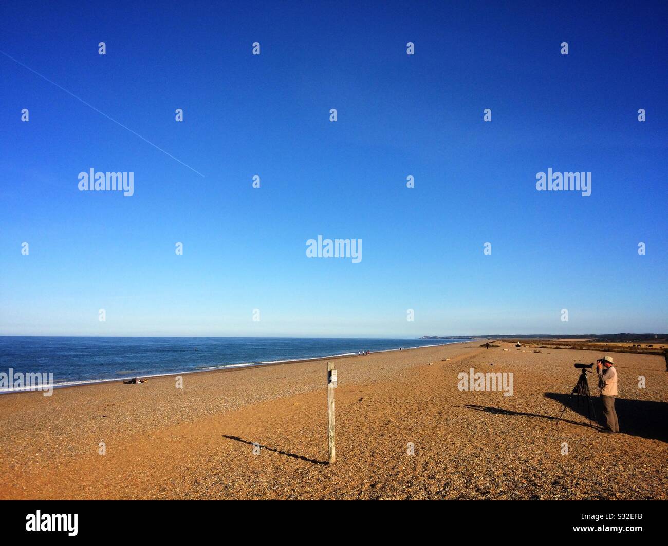 Birdwatcher on Cley beach, Norfolk UK - Smartphone Captured Stock Image