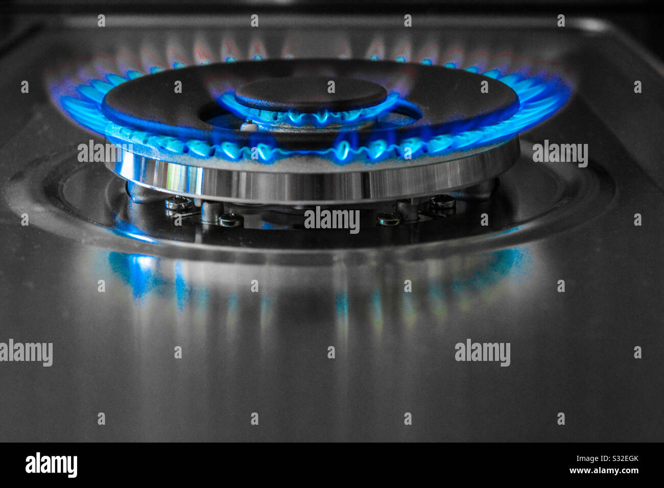 Gas stove burner with blue flame, pop color Stock Photo