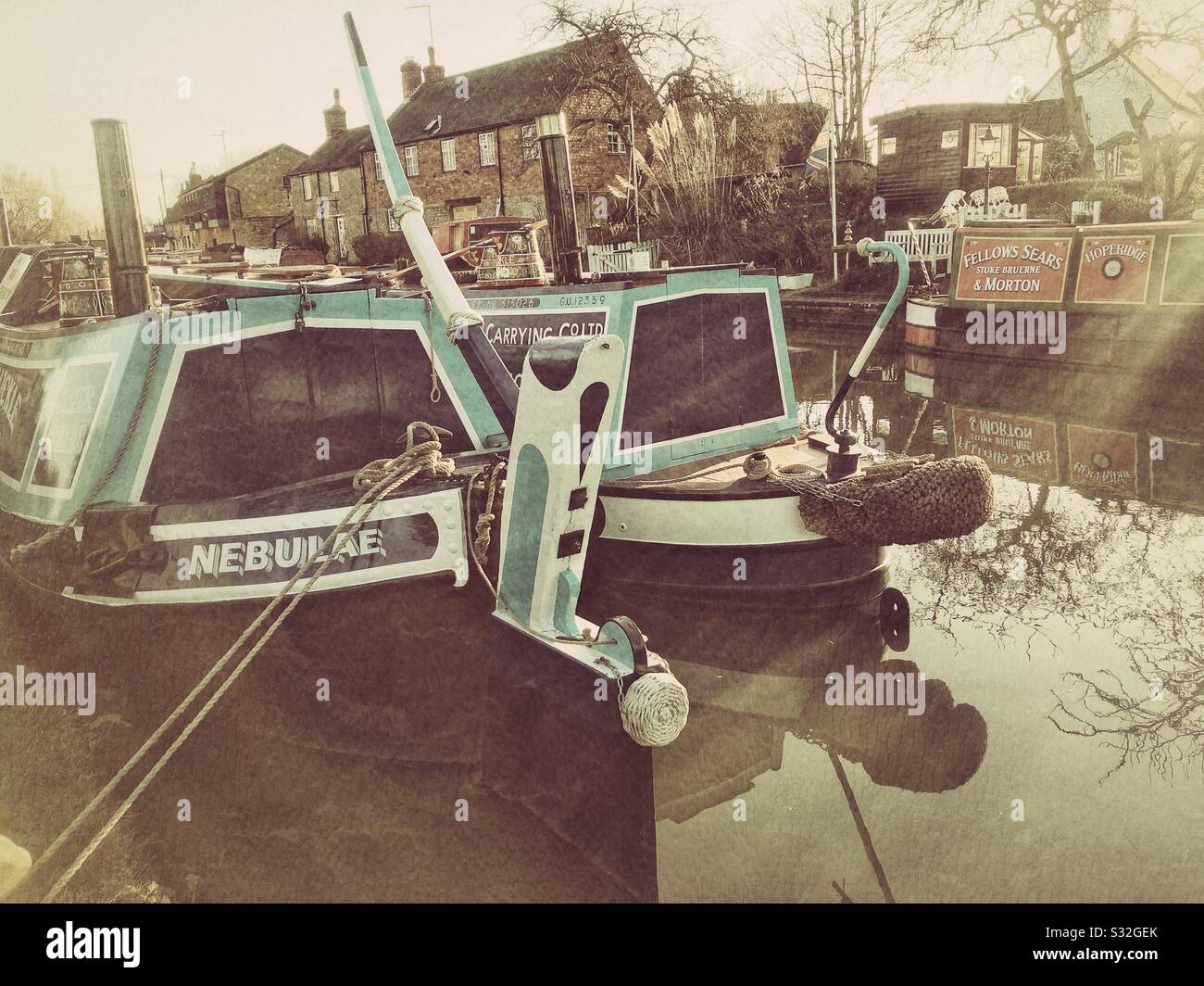 Narrowboats moored on the canal at Stoke Bruerne, UK; textured filter added. - Smartphone Captured Stock Image