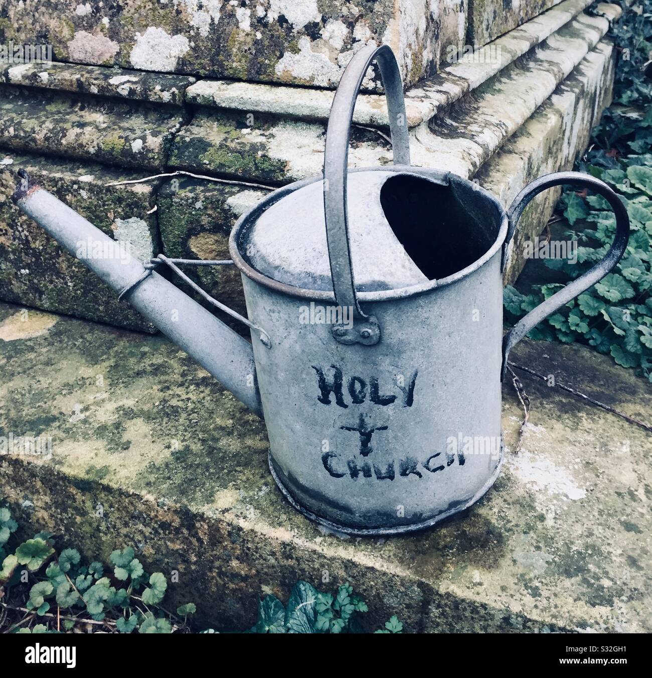 Watering can found on a grave on the Isle of Wight saying Holy + church Stock Photo