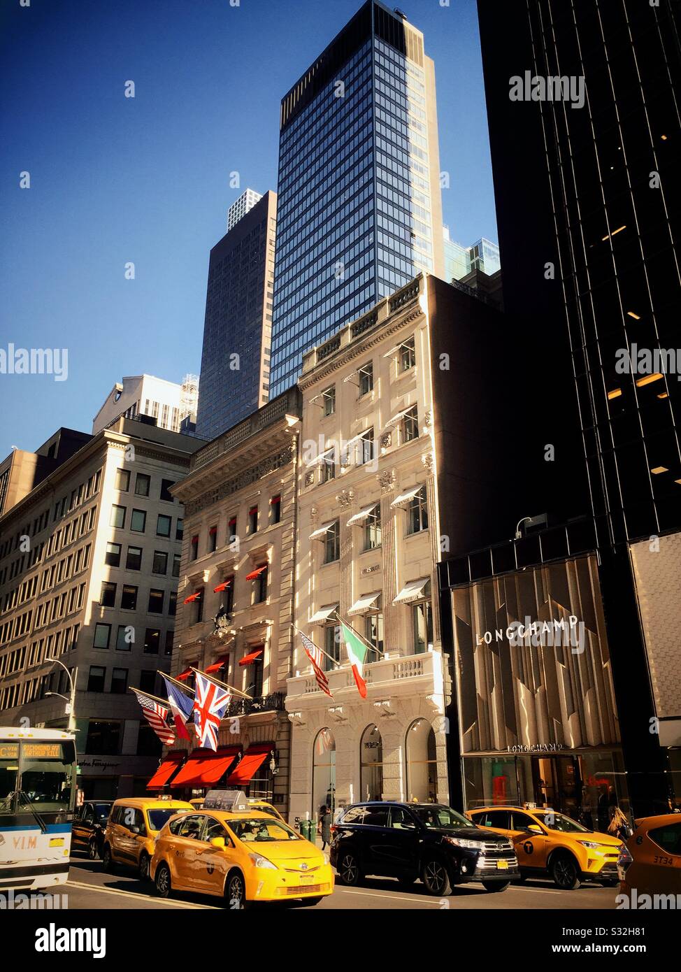 Taxis move down fifth Avenue in front of World famous high-end stores in New York City, USA - Smartphone Captured Stock Image