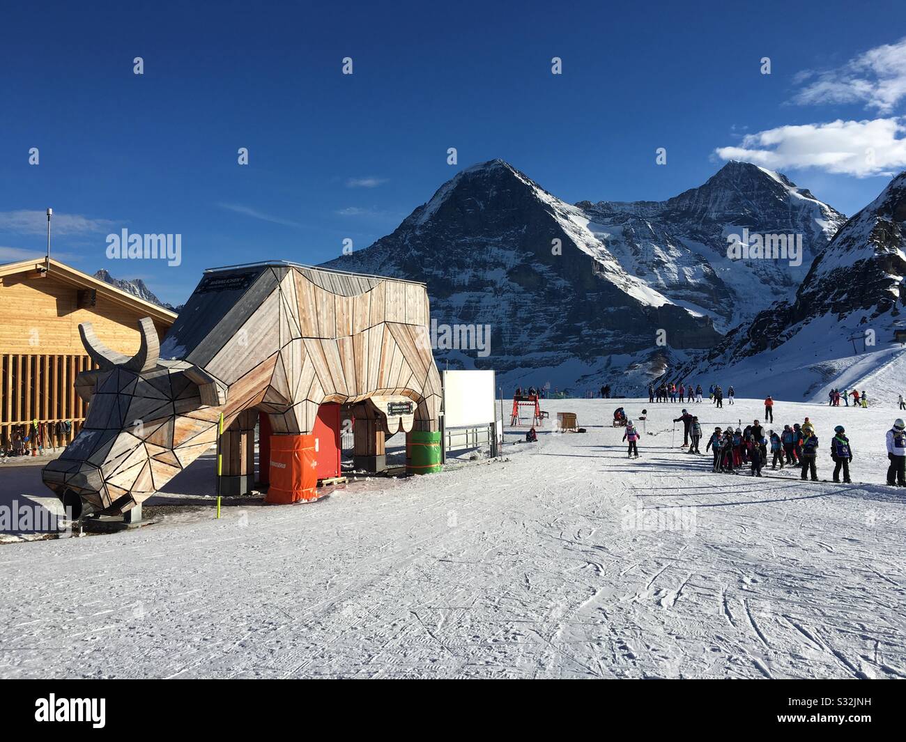 Skiarea Männlichen with wooden cow, in back mtns. Eiger (l) and Mönch, Grindelwald, Switzerland. Stock Photo