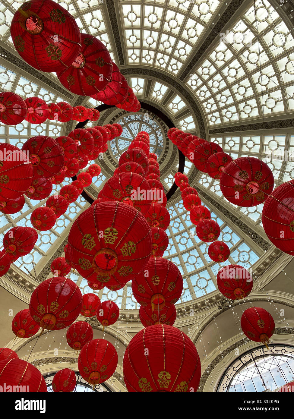 Red lantern decorations for Chinese New Year hung from the skylight of a shopping mall atrium - Smartphone Captured Stock Image