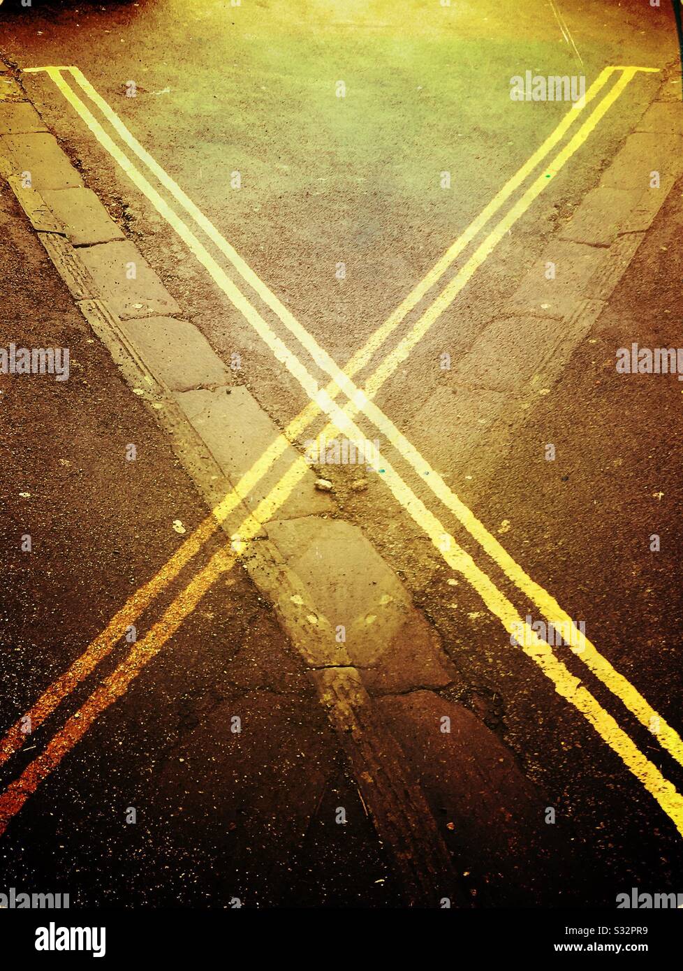 Double yellow lines on a road in the U.K., with a crossover mirrored