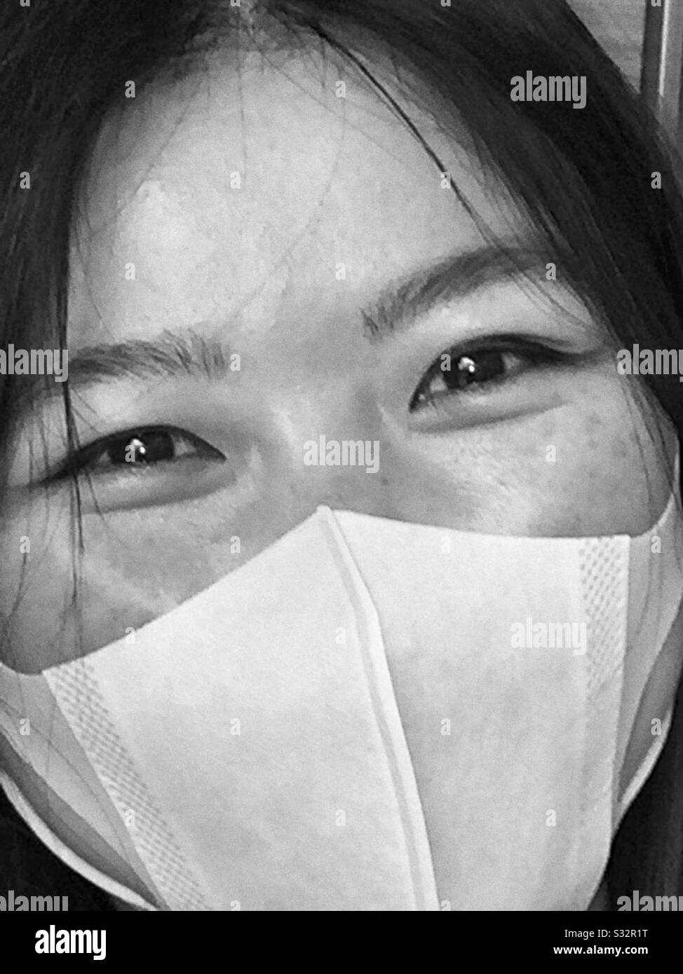 A young Chinese woman wearing a mask. - Smartphone Captured Stock Image