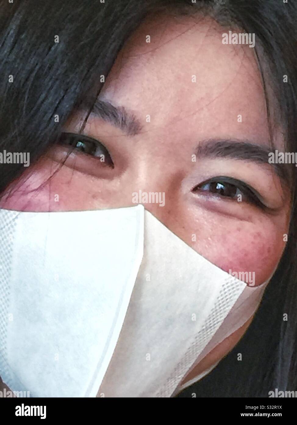 An young oriental woman wearing a surgical mask. - Smartphone Captured Stock Image