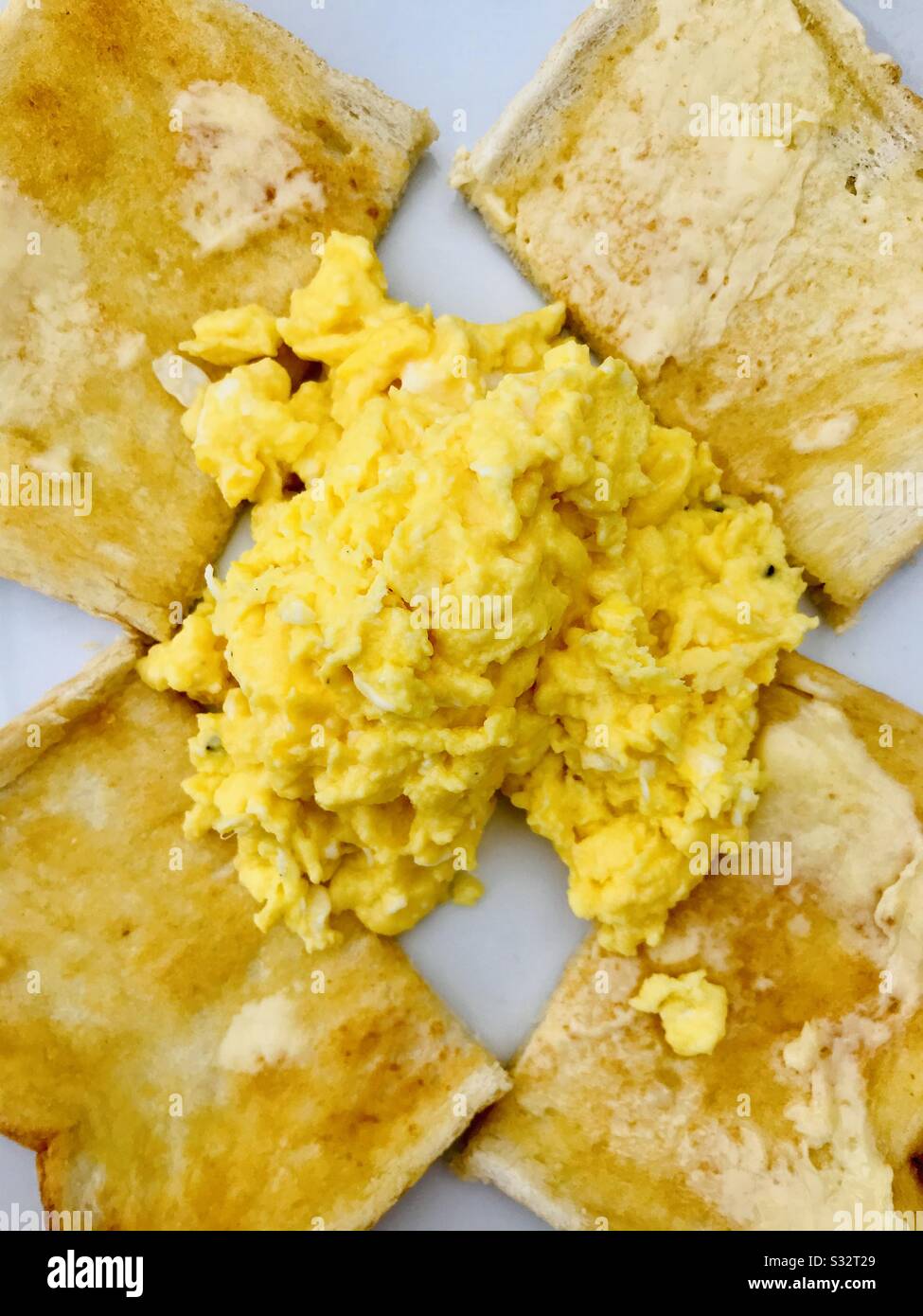 Scrambled eggs with white buttered toast Stock Photo Alamy