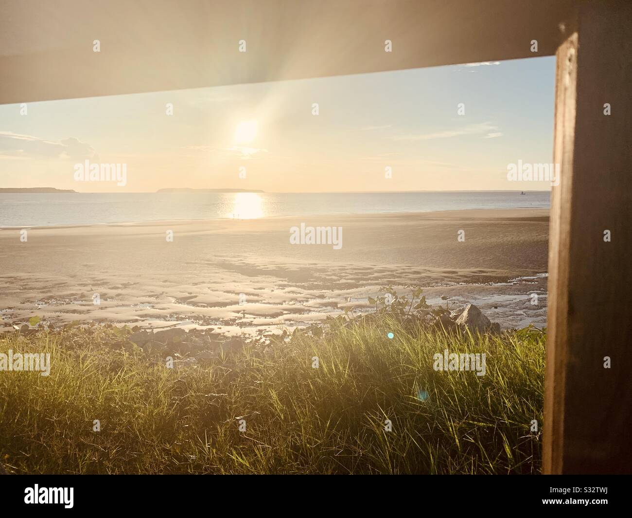 Wooden parapet framing beautiful sunset on the beach Stock Photo