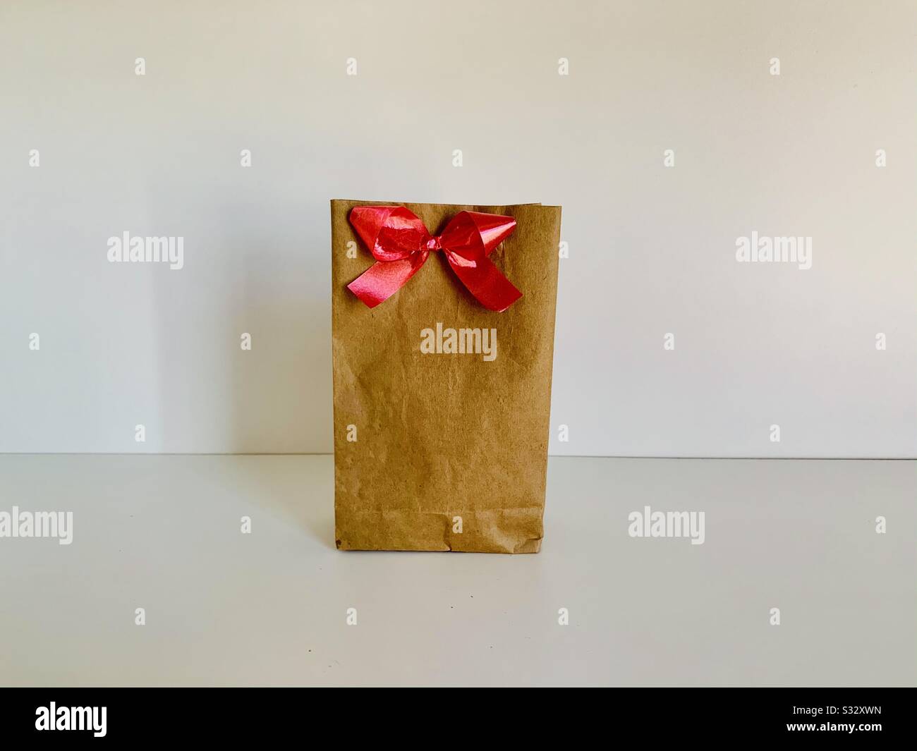 Gift wraped with red bow. Stock Photo