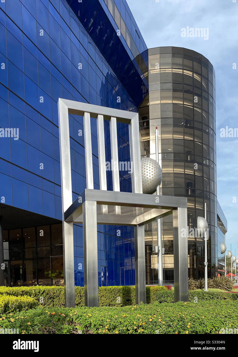 Unique architecture with a very large steel chair in front of building - Smartphone Captured Stock Image