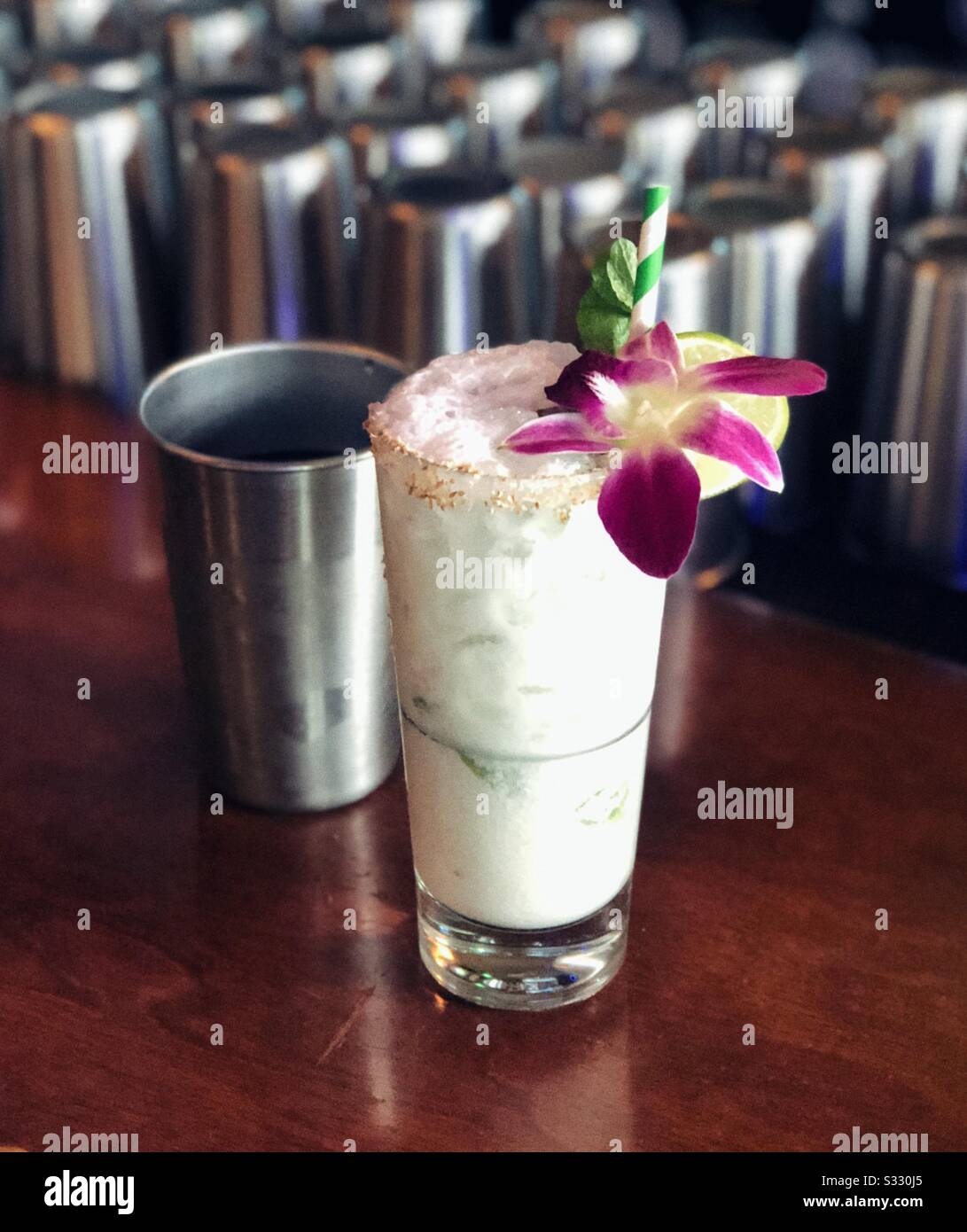 Fancy coconut cocktail with orchid in trendy vegan bar in Seattle - Smartphone Captured Stock Image
