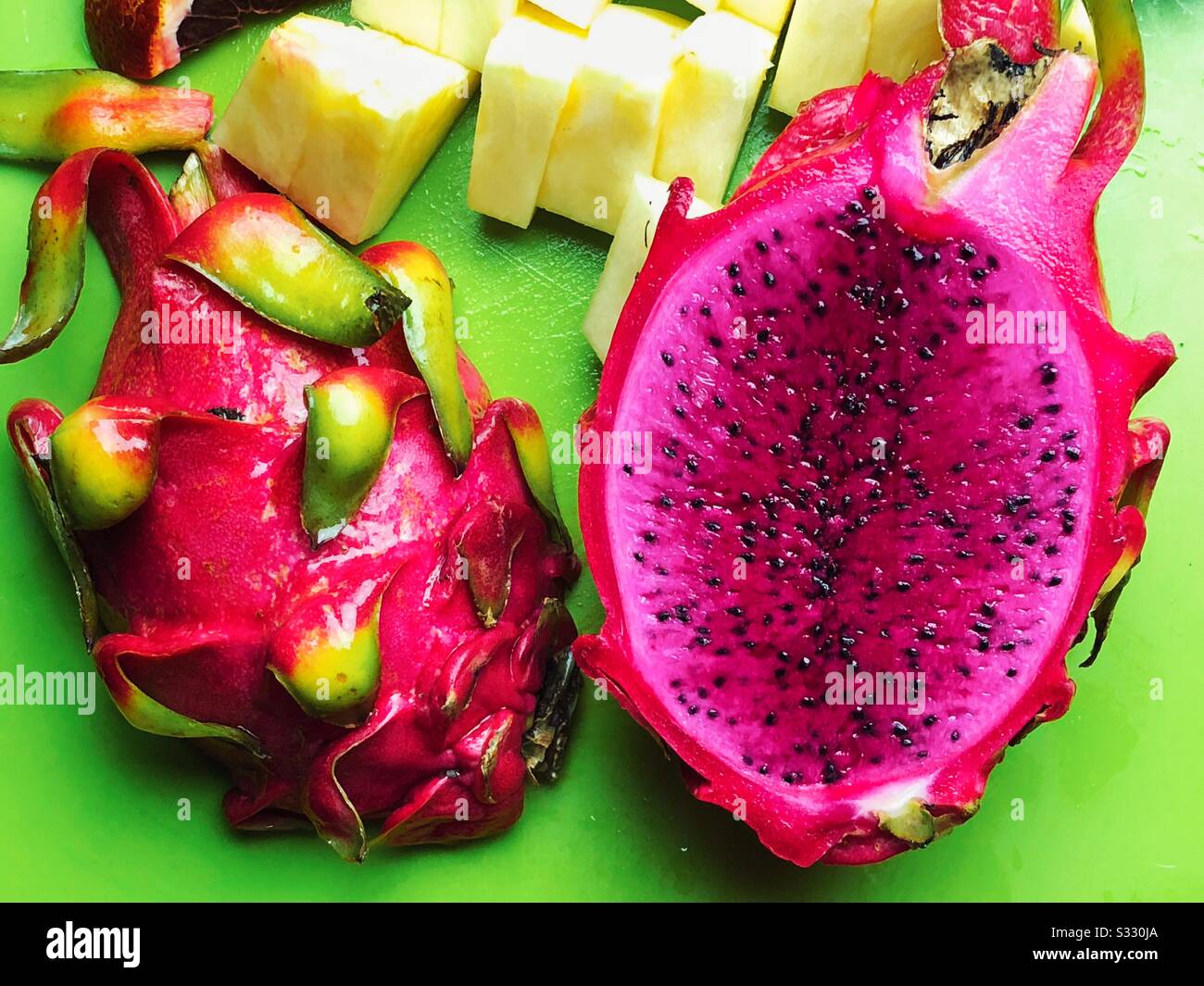 Red dragon fruit on green cutting board Stock Photo