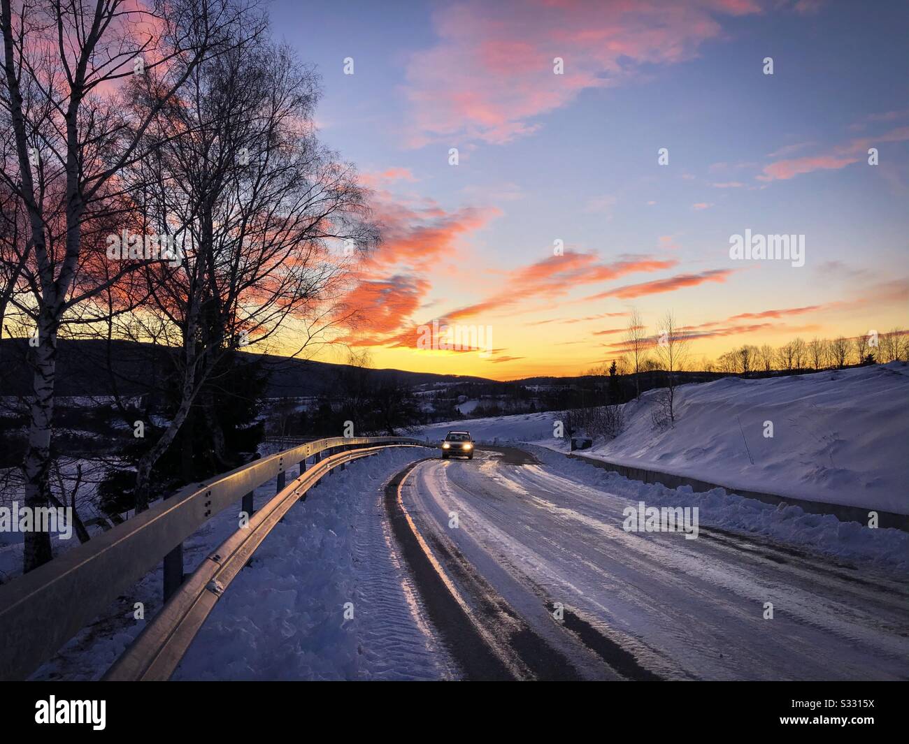 Car driving on winter road at sunset - Smartphone Captured Stock Image