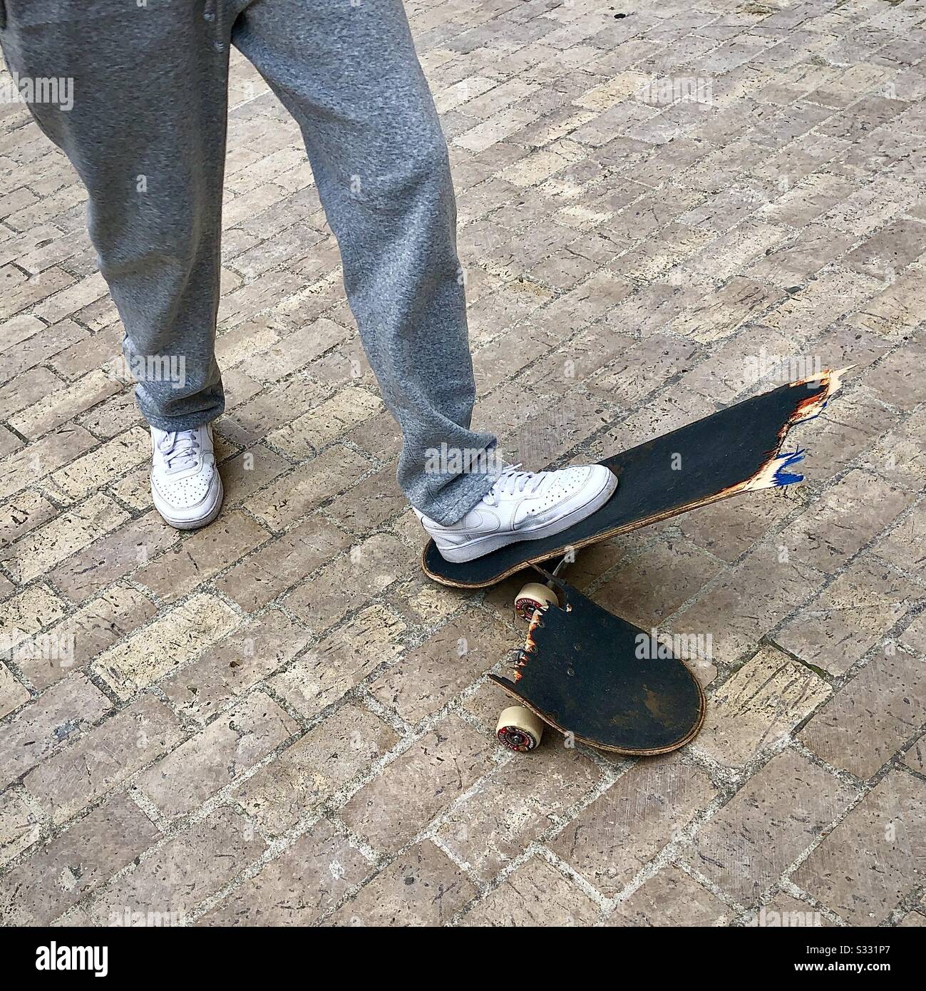 Teenager with his broken skateboard. Stock Photo