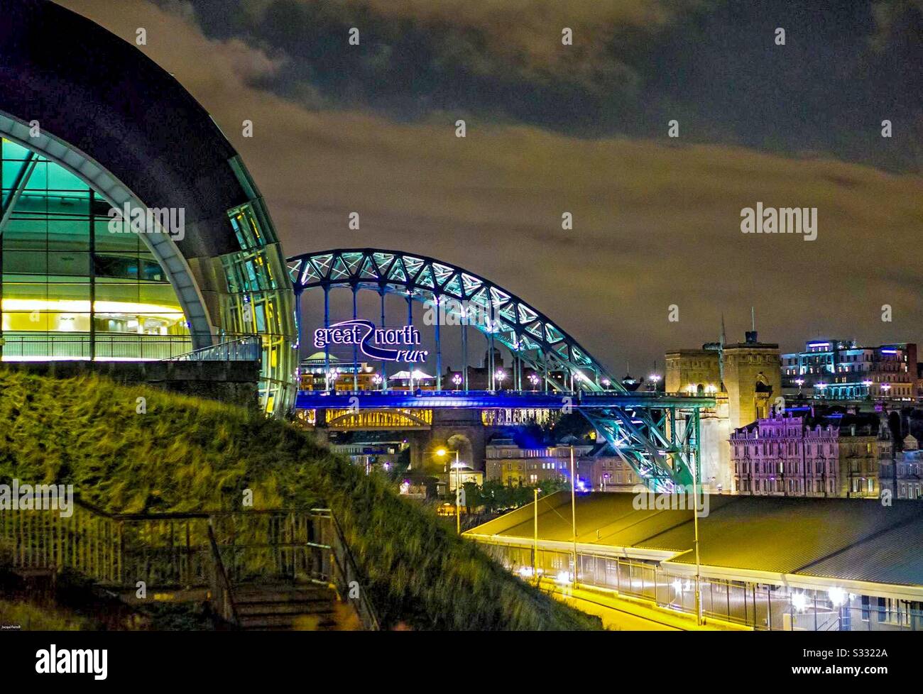 River Tyne in Newcastle showing Sage building and the Tyne Bridge lit up at night - Smartphone Captured Stock Image