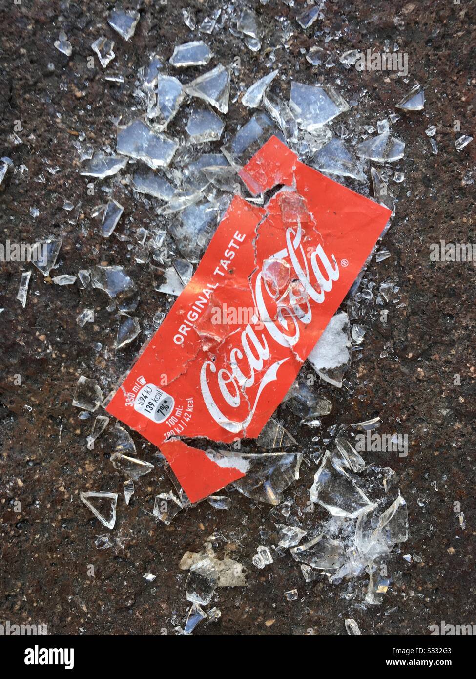 Coca Cola bottle broken on the sidewalk Stock Photo