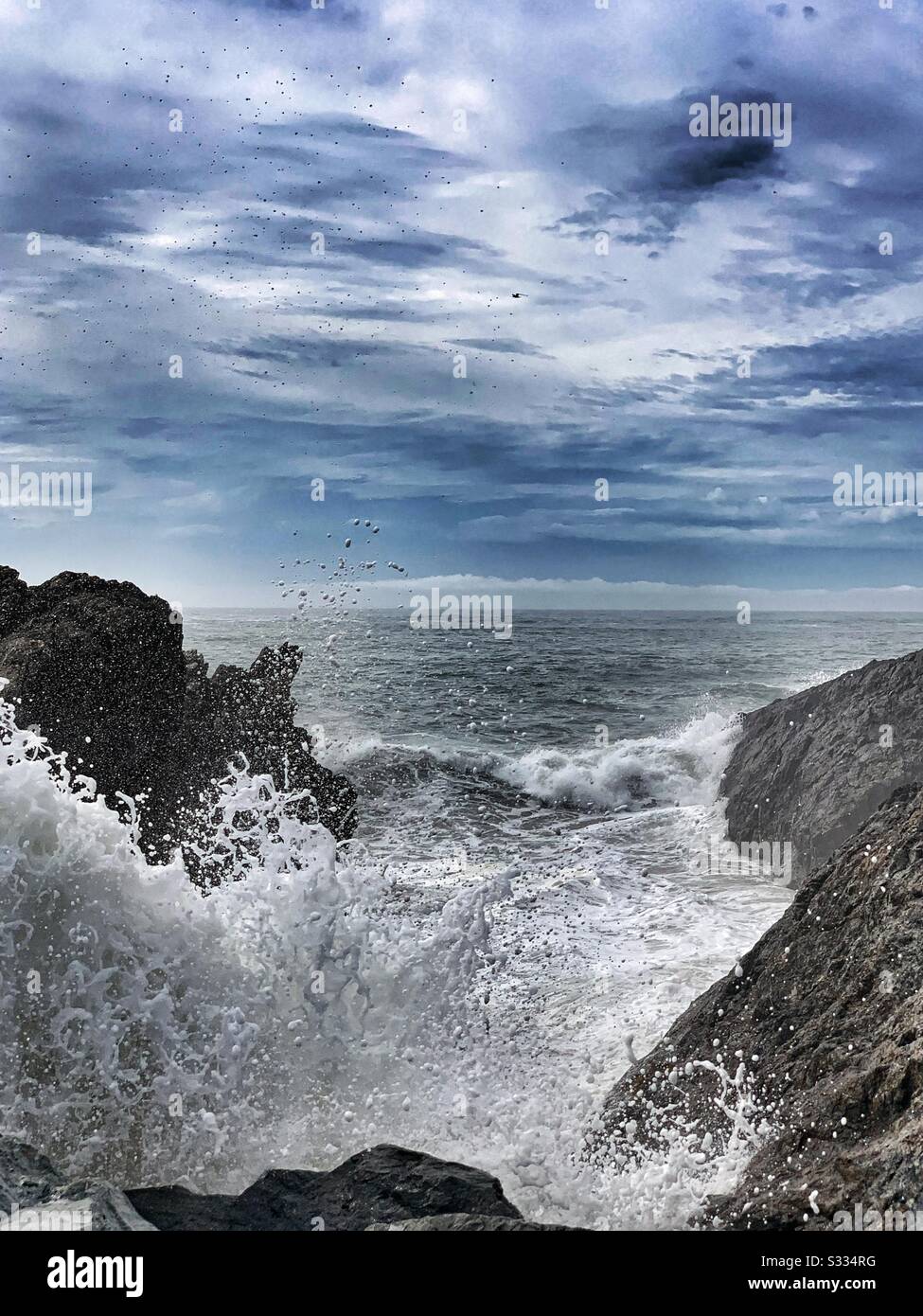 Foamy water splashing up as waves crash into break wall - Smartphone Captured Stock Image
