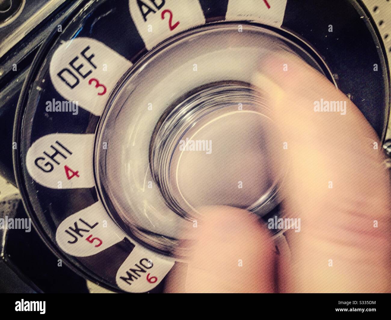Caucasian man dialing a retro rotary dial telephone, USA - Smartphone Captured Stock Image
