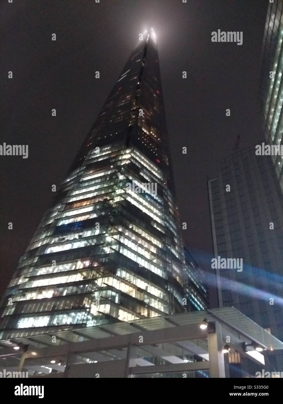 The Shard in London at night, with its tip in a cloud Stock Photo