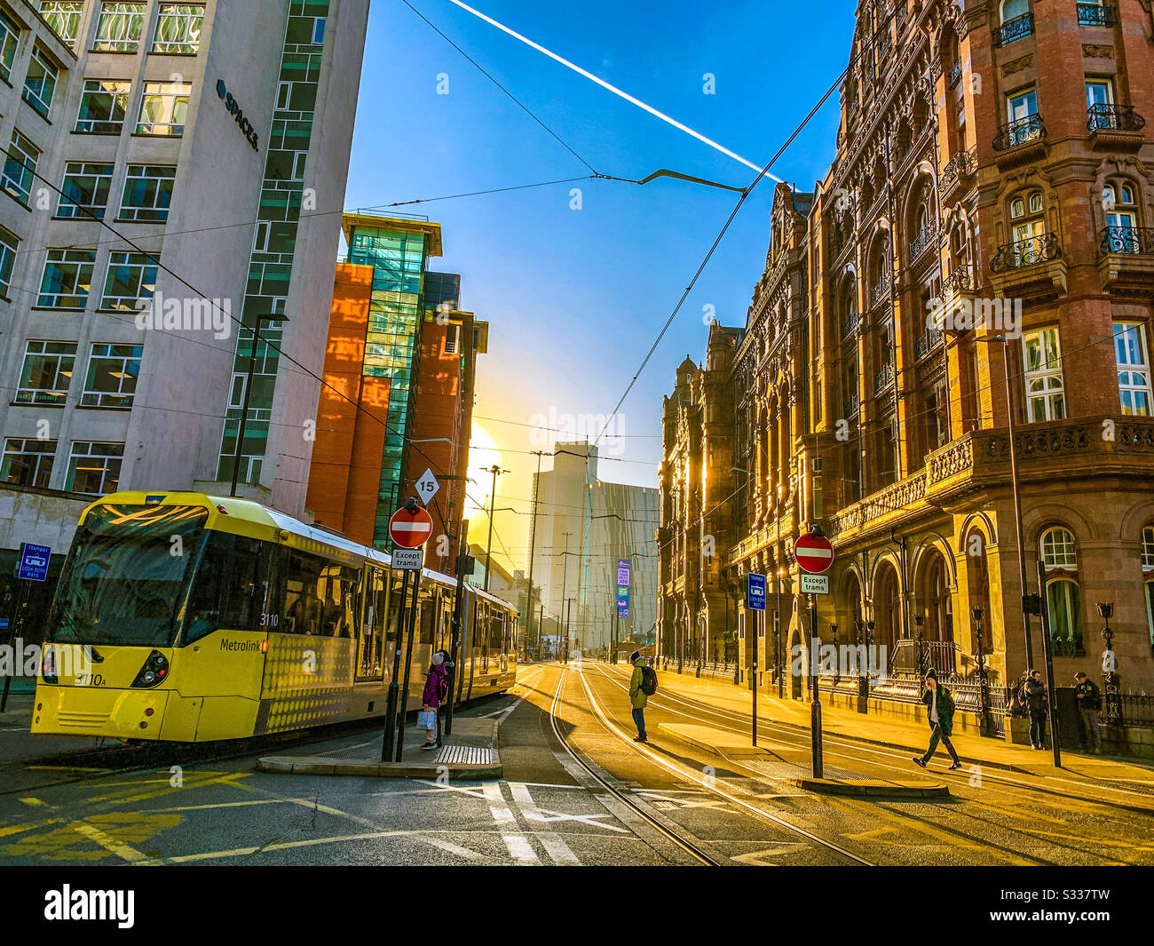 Metrolink tram passing in Manchester City centre during sunset - Smartphone Captured Stock Image
