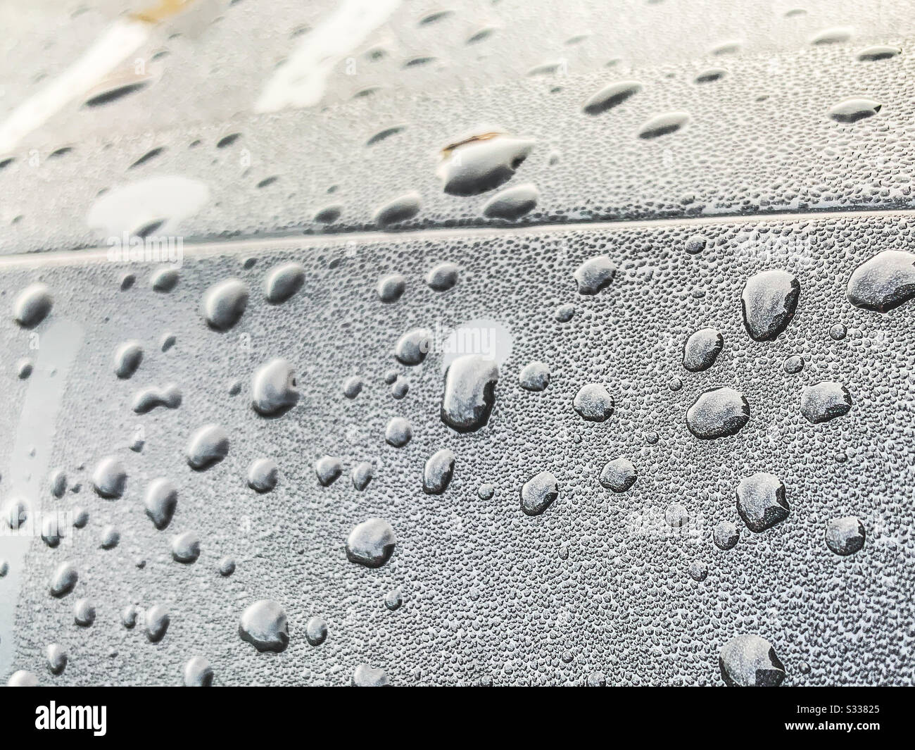 Close up of water droplets on black surface Stock Photo