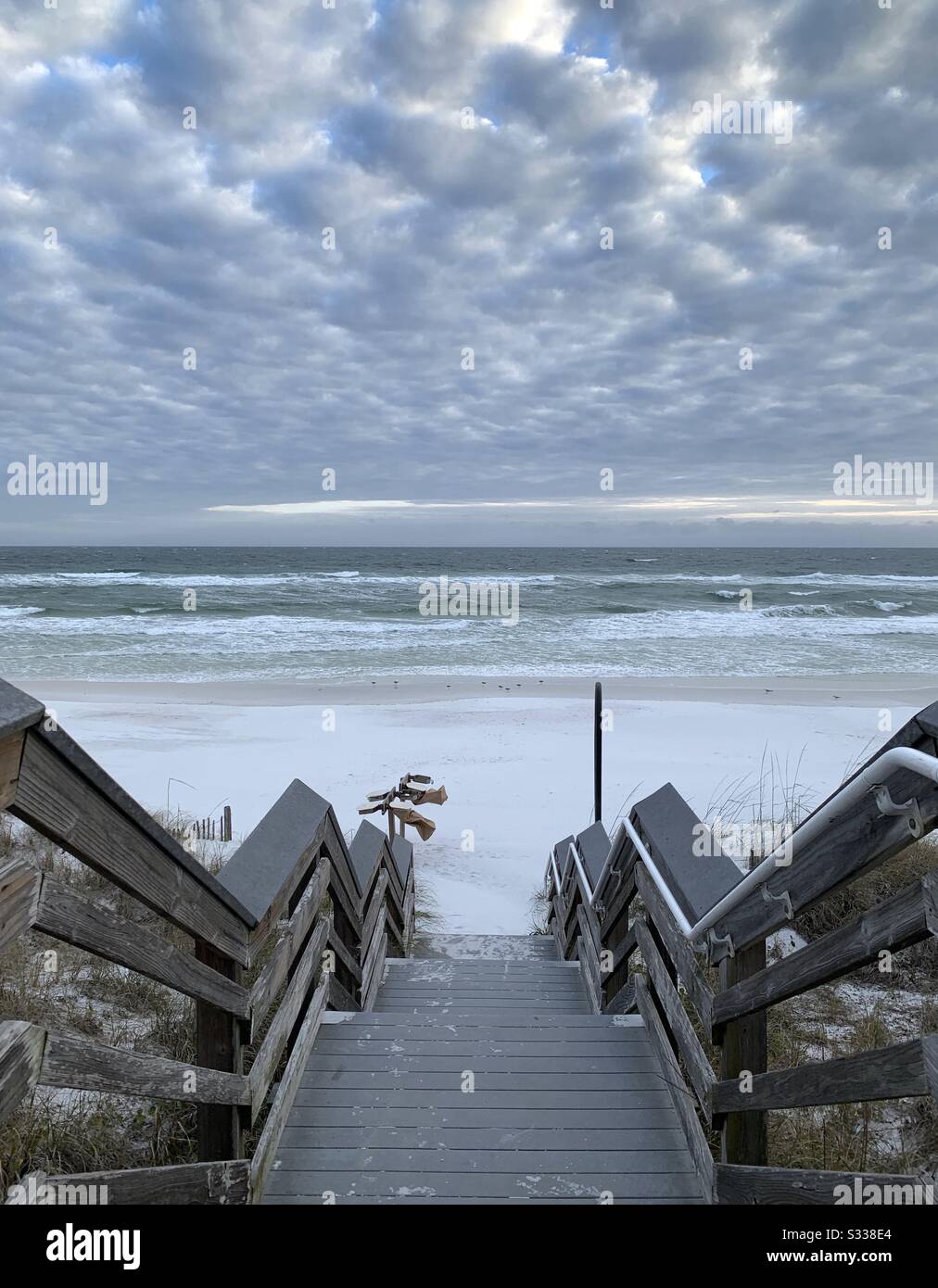 Wooden walkway to the beach with puffy white clouds in the sky - Smartphone Captured Stock Image