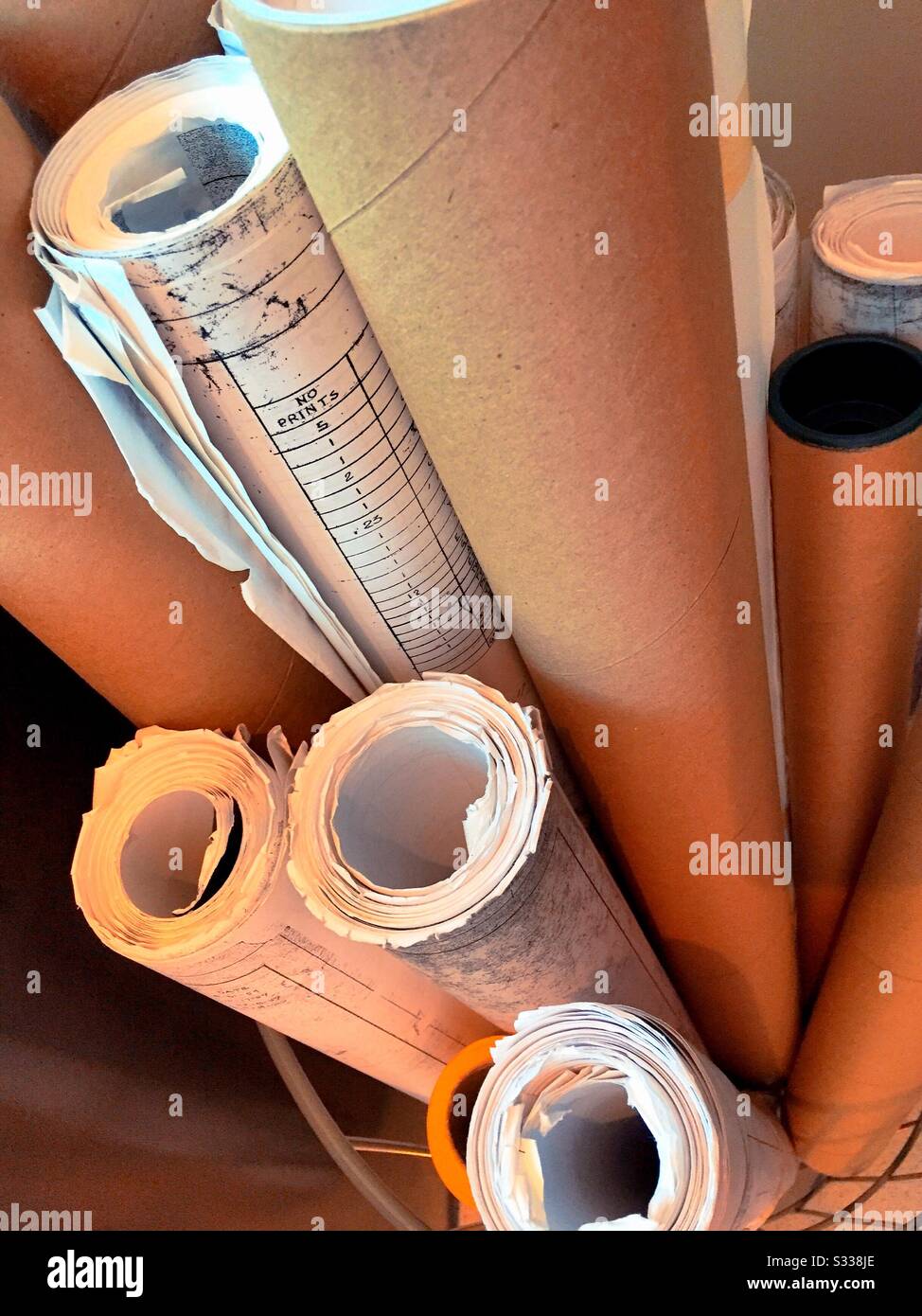 Vintage roles of blueprints in an architects workspace, USA - Smartphone Captured Stock Image
