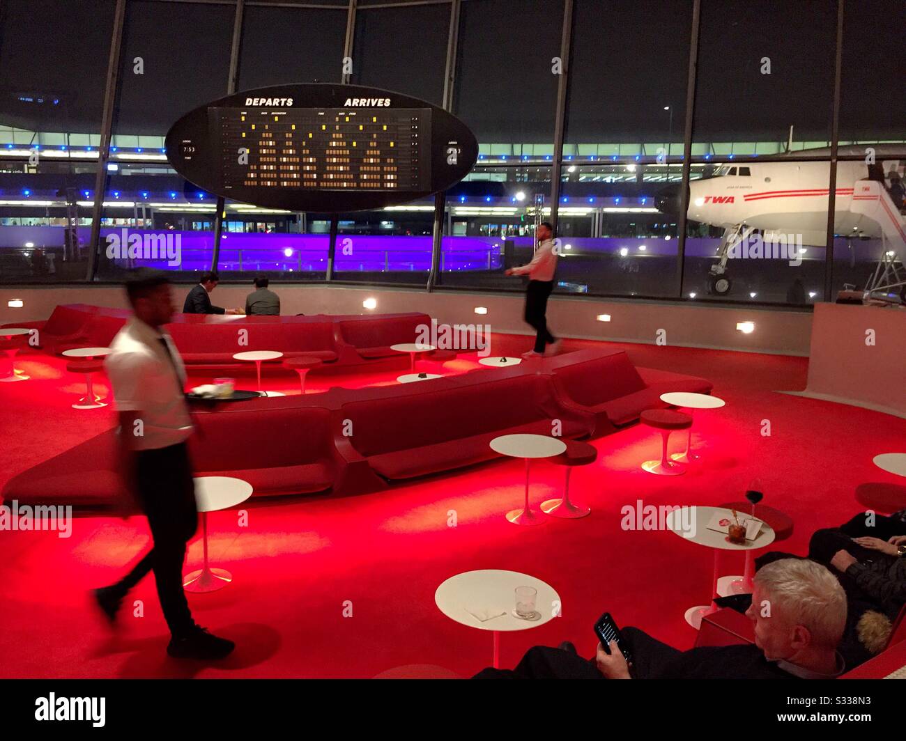 The sunken lounge is in the heart of restored terminal four, TWA hotel located at the JFK Airport in New York City, United States - Smartphone Captured Stock Image