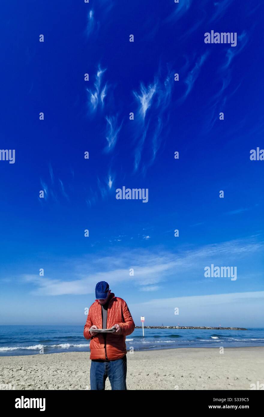 Reading the morning paper on the beach in Tel-Aviv. - Smartphone Captured Stock Image