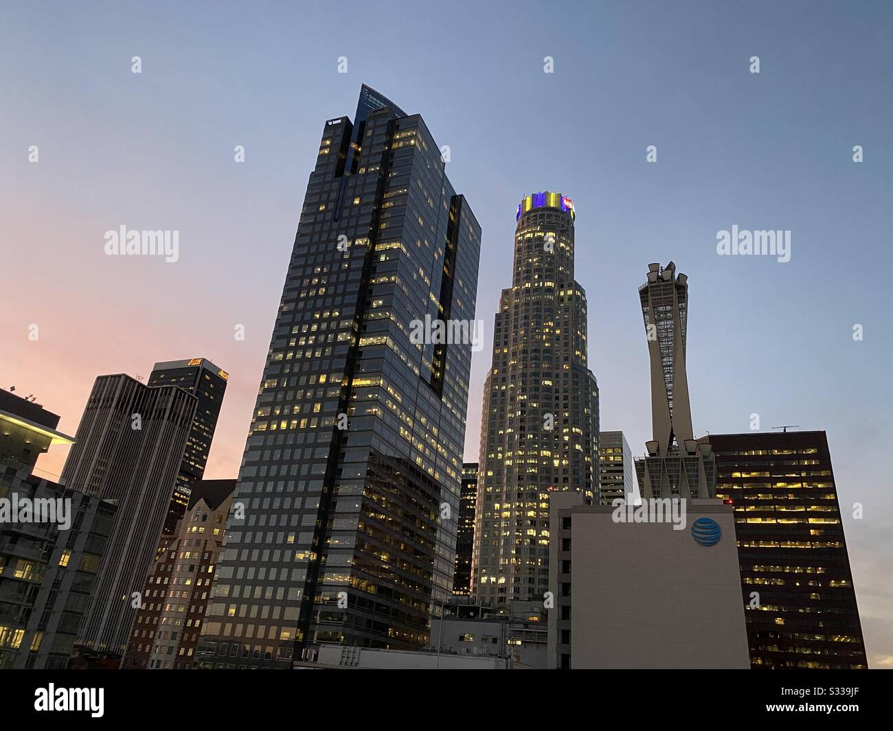 LOS ANGELES, CA, JAN 2020: Downtown skyscrapers at dusk with lights on top of US Bank Tower showing purple and yellow, LA Lakers basketball team colors in memory of player Kobe Bryant Stock Photo