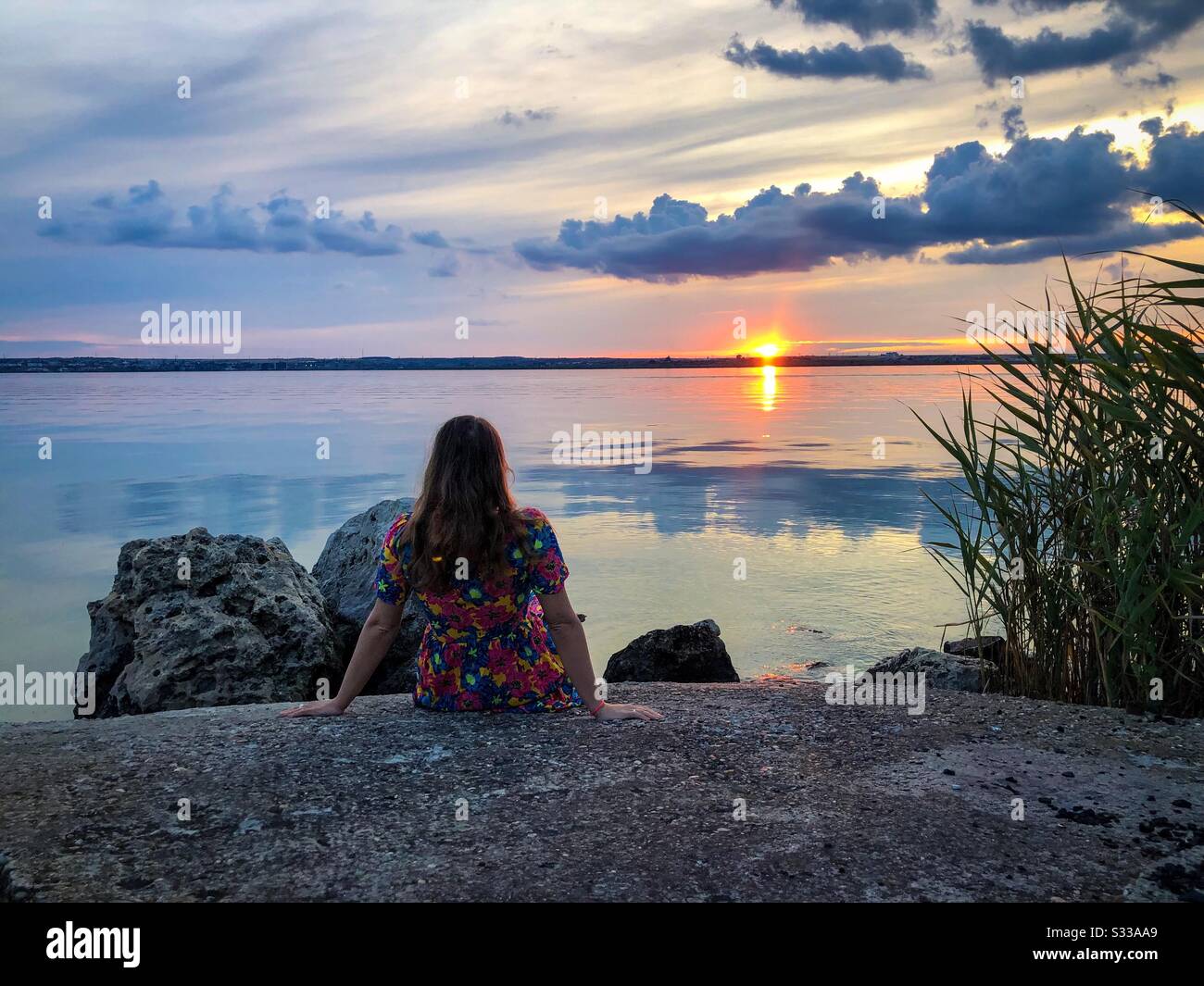 Woman watching the sunset on the beach - Smartphone Captured Stock Image