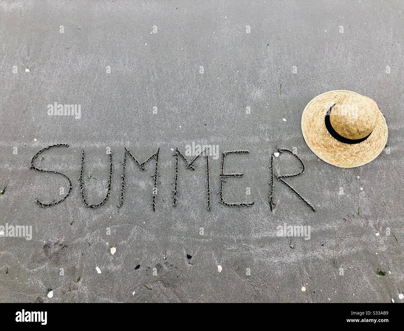 Summer written on sand near a hat - Smartphone Captured Stock Image